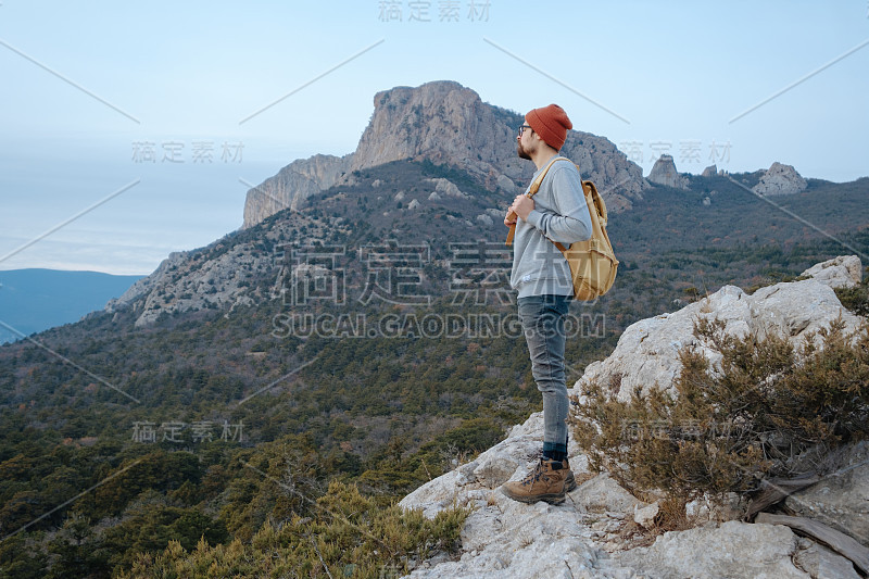 男人背包徒步旅行和红帽子在山区