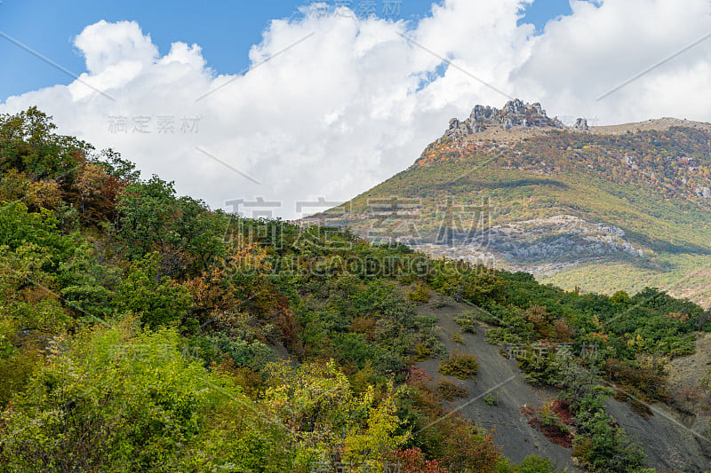 克里米亚南部海岸景色如画的秋天山坡上的克里米亚山脉。在远处，你可以看到著名的德默尔吉山和蓝天白云。