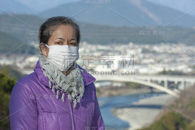 美丽的混血儿中年妇女戴着白色口罩，以抵御新型冠状病毒(SARS-CoV-2)等传染性疾病。前视图。