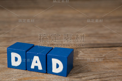 蓝色的立方体形状与白色的爸爸文本在桌子上