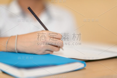 一个亚洲小男孩用铅笔在笔记本上写作业