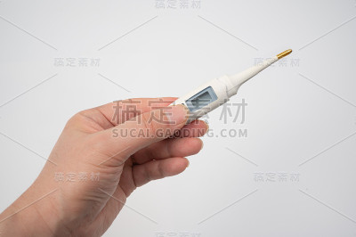 白色背景上，一只男性的手拿着一个数字温度计