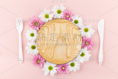 装有花和餐具的木制盘子