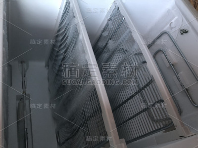 带门的冷冻室。覆盖着雪和冰的冰箱打开解冻。在冰箱里，雪和冰正在融化，冻结在墙上和架子上。