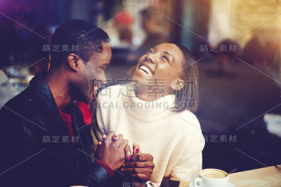 年轻幸福的男人和女人一起大笑，坐在现代餐厅的咖啡休息，愉快的夫妇相爱的脸上挂着微笑，享受休息和美好的