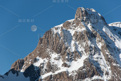 在比利牛斯雪山的背景上，日出时的满月