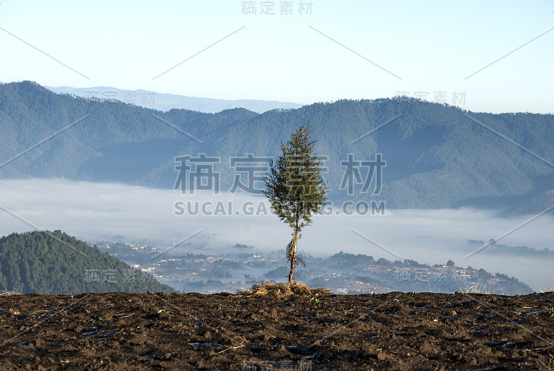 在危地马拉的乡村，日出的山峦上点缀着风景如画的村庄，有薄雾和霜冻