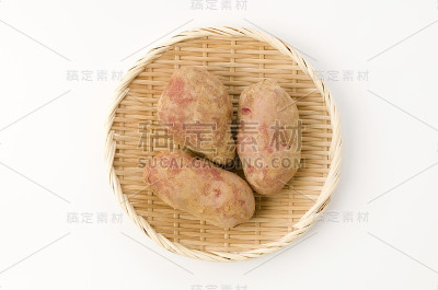 新鲜的红皮土豆与土壤竹滤在白色的背景