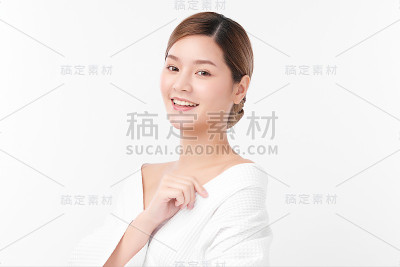 美丽年轻的亚洲女人穿着浴衣在白色的背景，面部护理，面部治疗，美容，美容和水疗概念。