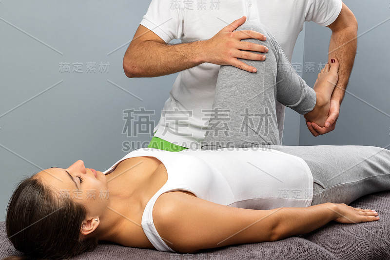 理疗师操纵女性的腿在治疗会议。
