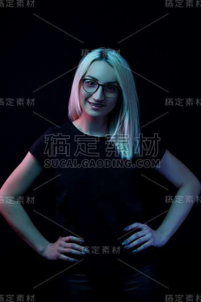 微笑的年轻白种人美丽的金发女人戴着眼镜。特写肖像在霓虹灯