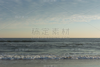 平静的波涛在海滩上翻滚着冲到岸边