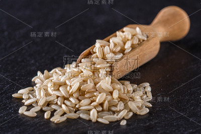 黑色石头背景上的生糙米
