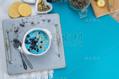白软干酪配果酱，新鲜蓝莓和南瓜子放在陶瓷碗里，特写。美味健康的早餐
