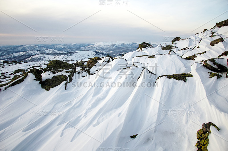 白雪皑皑的山峰映衬着连绵的山脉。徒步登山。