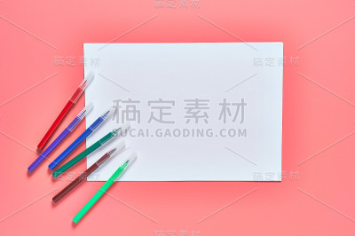 幼儿园粉红色的课桌上放着彩色毛毡笔和白纸。Ð’育儿和教育孩子的观念。副本的空间。俯视图