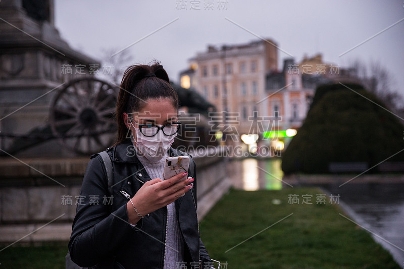 戴着面具的女人黄昏时分在街上打电话