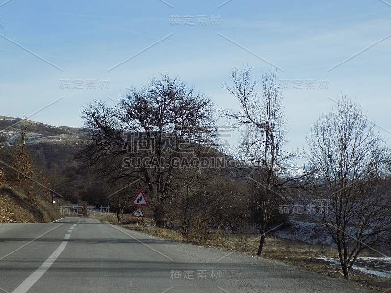 在湿滑道路上的双弯-高速公路上的弯道警告和湿滑道路标志