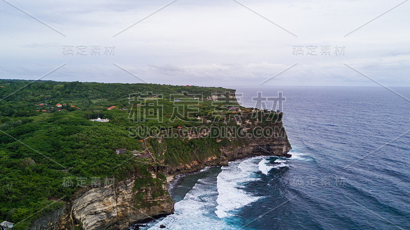 海上岩石海岸与冲浪的海浪鸟瞰图，巴厘岛，印度尼西亚，普拉乌鲁瓦图悬崖。海浪冲击着岩石海岸。海景、岩石