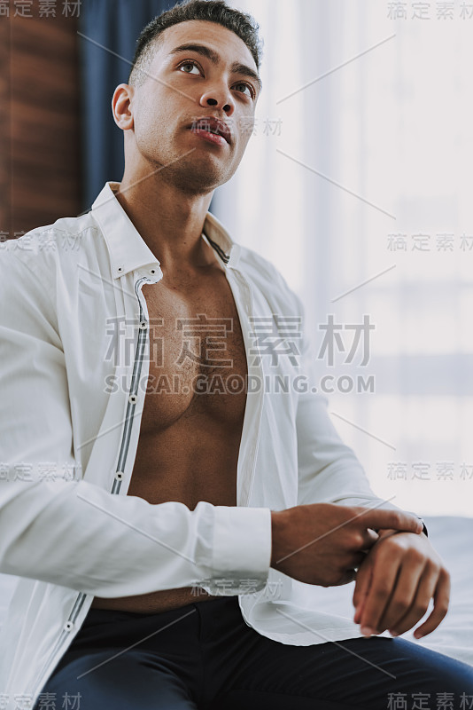 年轻英俊的男子正在家里穿衣服