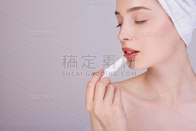 一个小女孩洗完澡后，闭上眼睛，涂上嘴唇。