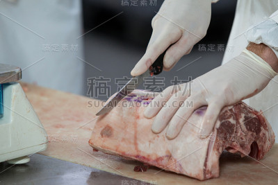 在肉厂切肉的屠夫