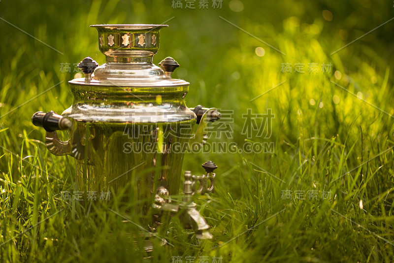 夏日清新的草坪上摆放着质朴的茶炊。Copyspace