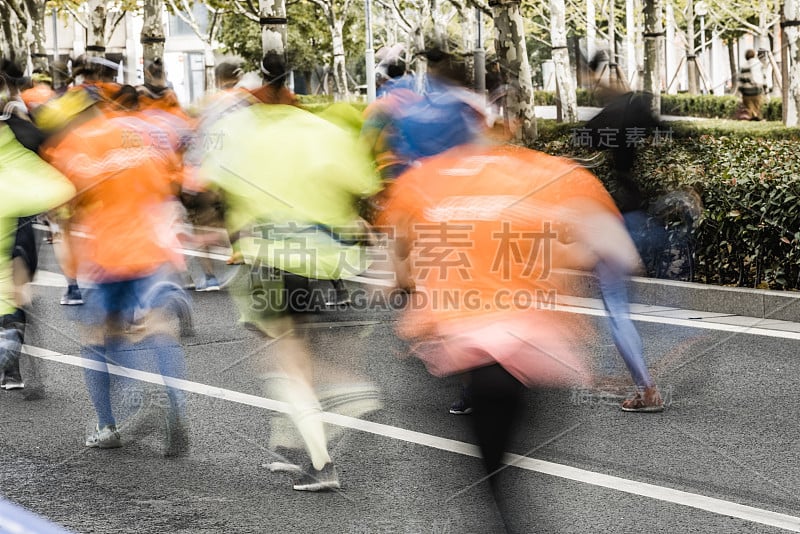 在城市街道上跑马拉松的人们。动态模糊。