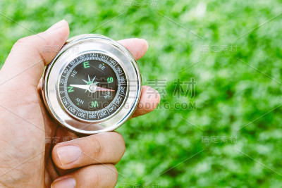 手握指南针在绿色背景
