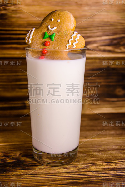 姜饼人在一杯牛奶放在木桌上
