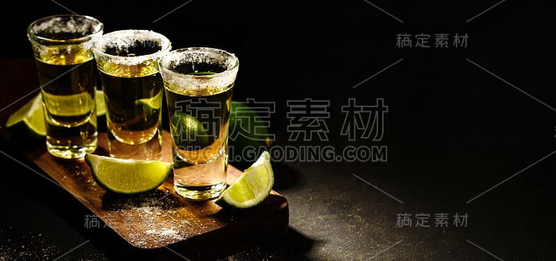 墨西哥金龙舌兰酒，酸橙和盐放在木桌上