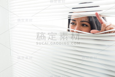 一个女人从窗帘里偷窥