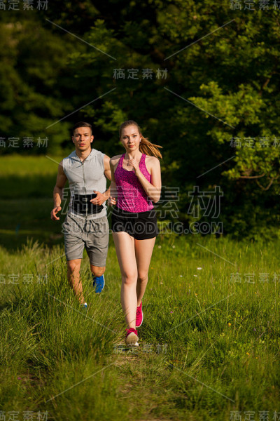 活跃的年轻夫妇在公园里跑步