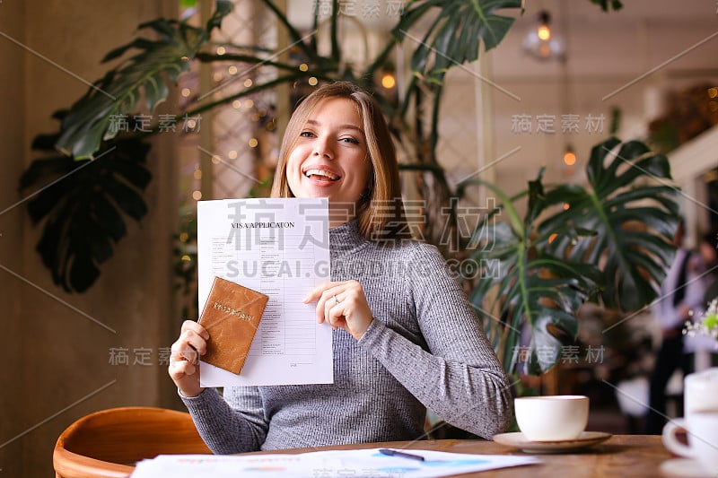 在旅行社柜台拿着护照和签证申请的漂亮女孩