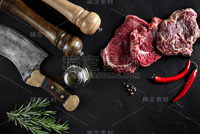 牛里脊片，用斧头切肉，用香料——迷迭香、胡椒煮在旧黑桌上。俯视图拷贝空间