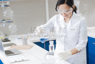 愉快的专业科学家与试剂一起工作
