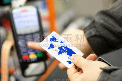 男性手拿银行卡在超市收银台付款