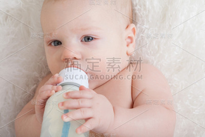 婴儿的特写肖像与瓶子。