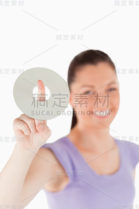 一个迷人的女人站着拿着CD