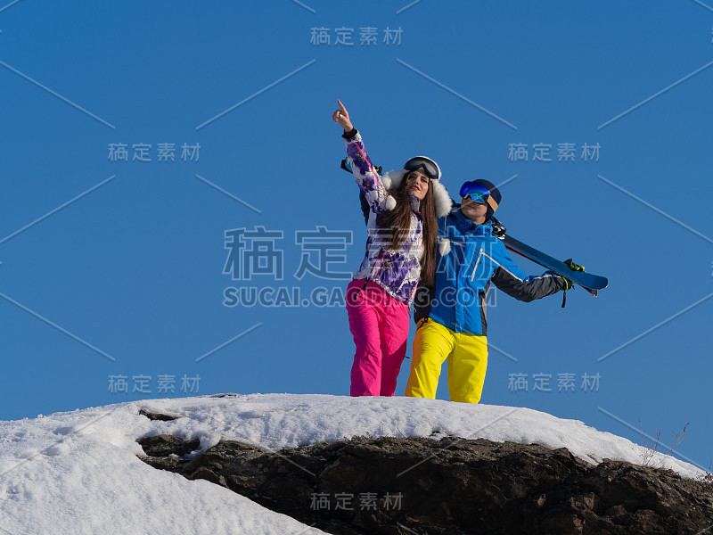 一对夫妇在一个滑雪胜地的山顶上休息。运动、健康和积极的生活方式理念。