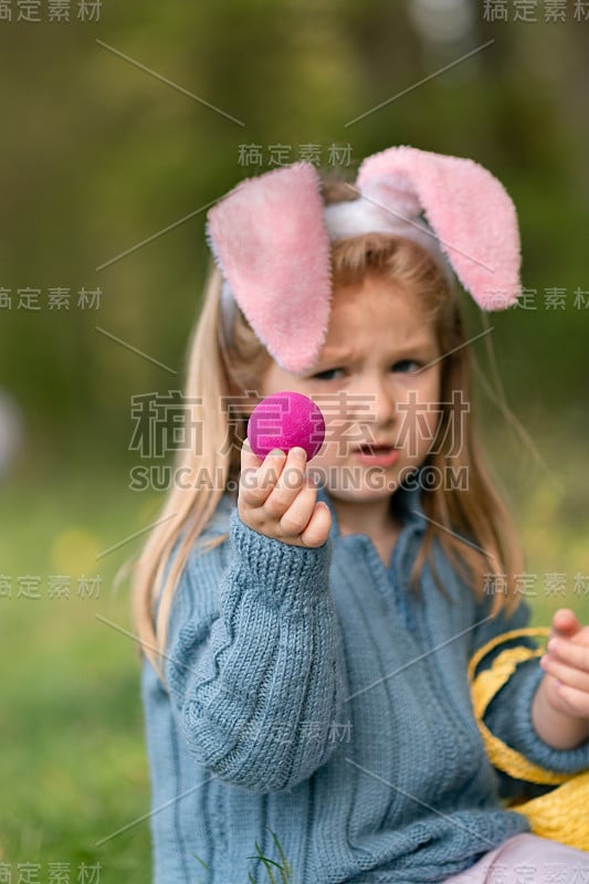 有兔耳朵的女孩为复活节收集巧克力蛋