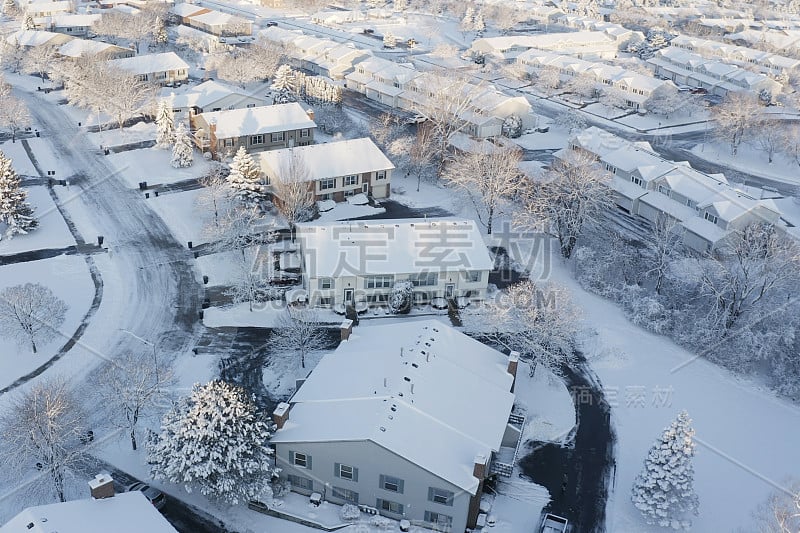 鸟瞰图的住宅，公寓，联排别墅覆盖雪在冬季。建立拍摄美国社区，郊区的冬季。中西部的房地产，阳光明媚的早