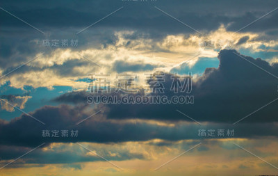 阳光普照的暴风雨天空。灿烂的日落与雨云。