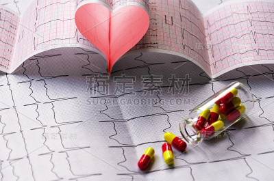 心脏珊瑚色，心脏打印输出和透明瓶红黄胶囊。心脏检查概念