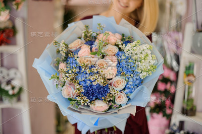 特写的女性与蓝色的花束在手中