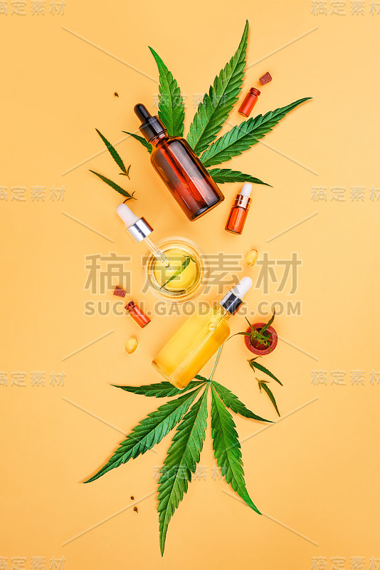 玻璃瓶与CBD油，四氢大麻酚酊剂和大麻叶黄色背景。平坦的躺,极简主义。化妆品CBD大麻油