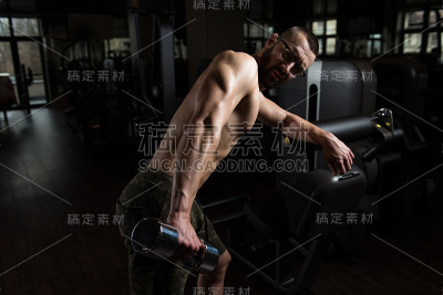 在健身房用哑铃锻炼三头肌