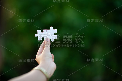 手和白色拼图近距离融合形象和经营理念而统一