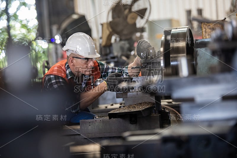 工人们正在一家工厂的车床上工作。车工在车床上管理机械切削的金属加工过程