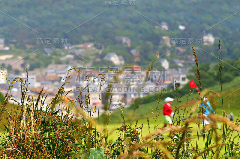 高尔夫球手在绿色的山草，高尔夫球场。埃特尔塔风景如画，从悬崖俯瞰古城。本的父亲,法国诺曼底